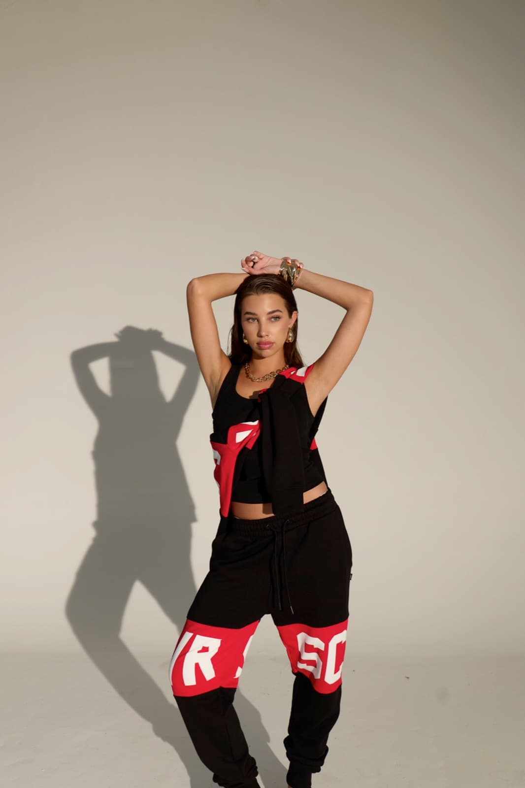VRSC Couture FW — modella in top nero e pantaloni con logo VRSC rosso