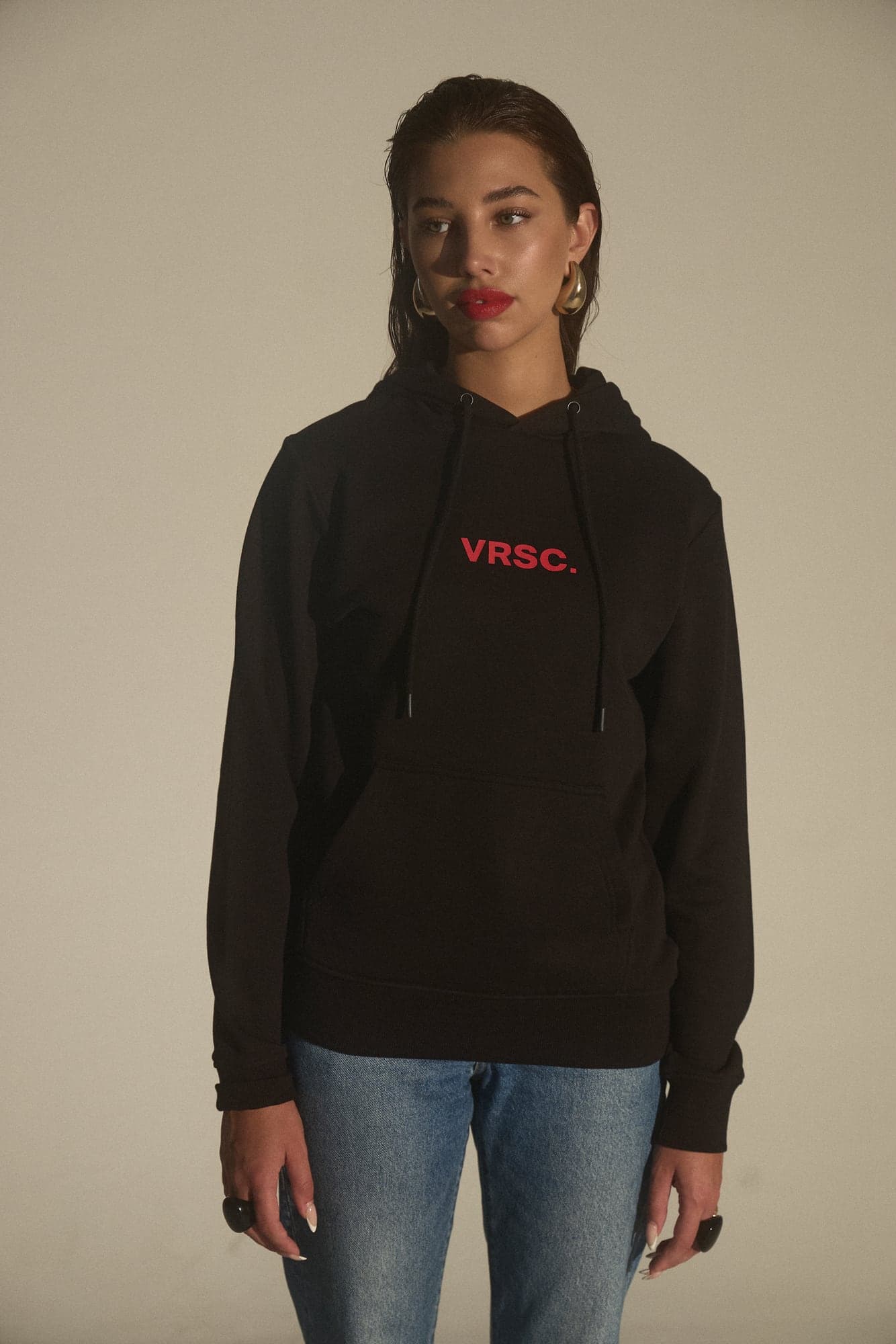 VRSC Couture — modella in felpa nera con scritta VRSC. rossa